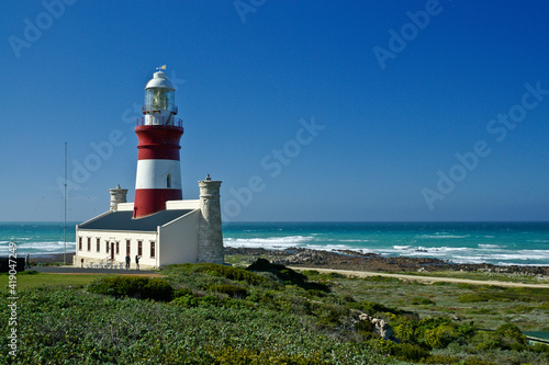 The red and white Cape Agulhas Lighthouse at the southern tip of Africa, where the Atlantic and Indian Oceans meet