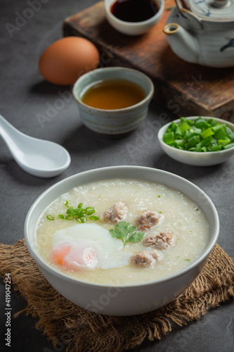 congee with minced pork in bowl on old dark background