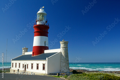 The red and white Cape Agulhas Lighthouse at the southern tip of Africa, where the Atlantic and Indian Oceans meet