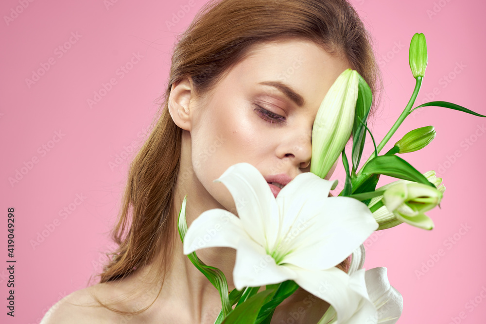 Beautiful woman with flowers on pink background makeup portrait model Beautiful woman with flowers on pink background makeup portrait model