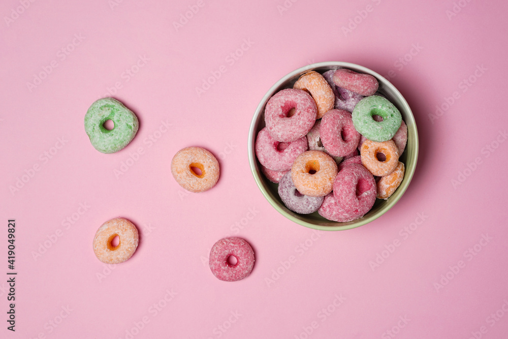 Colorful donuts with cute shapes in a bowl on a pink background. Sweet colorful donuts are perfect for snacks at home with your family and relatives. Delicious homemade sweet donuts. Colorful donuts with cute shapes in a bowl on a pink background. Sweet colorful donuts are perfect for snacks at home with your family and relatives. Delicious homemade sweet donuts.