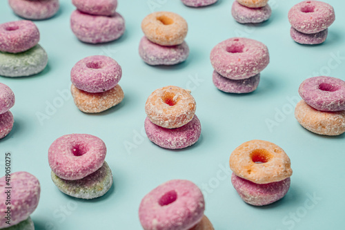 The arrangement of donut pairs of various colors from a perspective point of view with the composition of the rules of third. Donut wallpaper from perspective angle on blue background