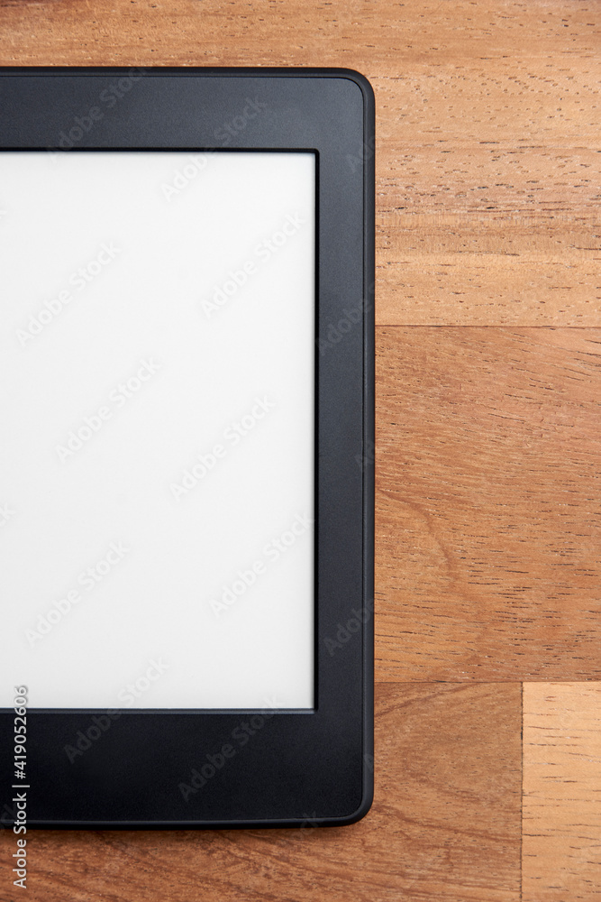 Closeup image of an electronic reader with blank screen on a wooden surface Closeup image of an electronic reader with blank screen on a wooden surface