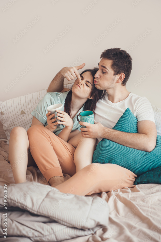 Lovely couple playing in the morning while having a tea in bed Lovely couple playing in the morning while having a tea in bed