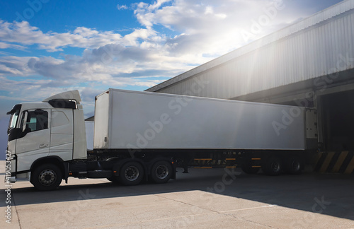 Cargo Trailer Truck Parked Loading at Dock Warehouse. Cargo Shipment. Induatry Freight Truck Transportation. 