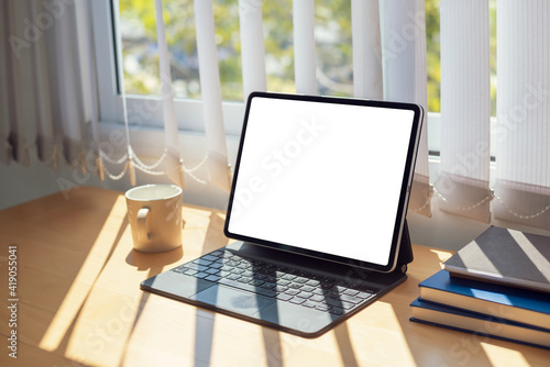 Mock up. image of tablet white blank screen with papers placed at the office.