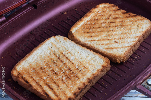 Two pieces of toasted bread in a grill pan. Close up.