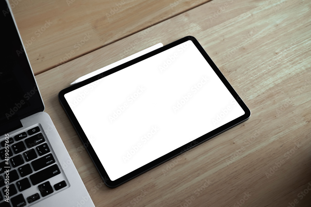 Cropped shot of mock-up digital tablet with blank white screen on desk. Cropped shot of mock-up digital tablet with blank white screen on desk.