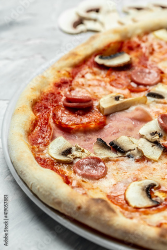 Tasty Capriciosa pizza. Classic pizza with ham and mushrooms. Italian pizza is cooked in a wood-fired oven. vertical image, Food recipe background. Close up