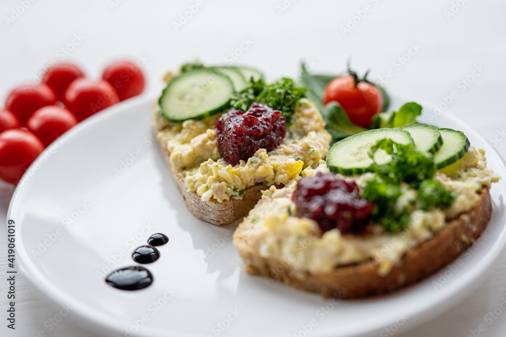 sandwich dip bread spread with salad vegetables on white porcelain plate 