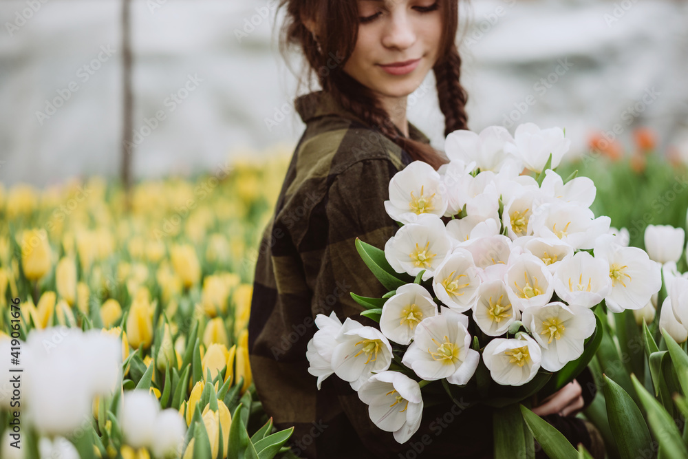 Young woman with a bouquet of spring flowers tulips. Soft selective focus, defocus.