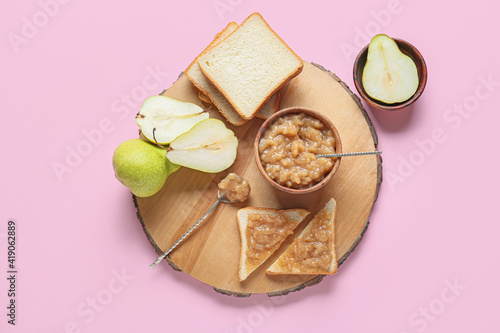Bowl of tasty pear jam and bread on color background