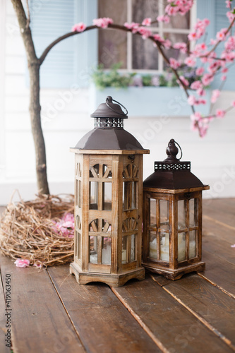 Two Vintage wooden lanterns on spring background of sacura (cherry) blossom. Spring and Easter mood