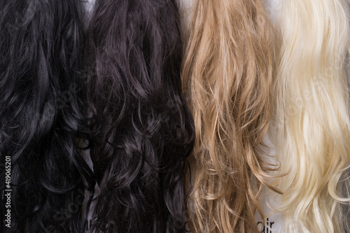 Women's wigs of different shades. Blonde brunette brown-haired woman.