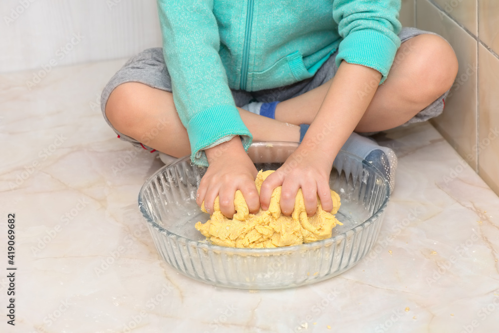 Hands of a child kneading dough Hands of a child kneading dough