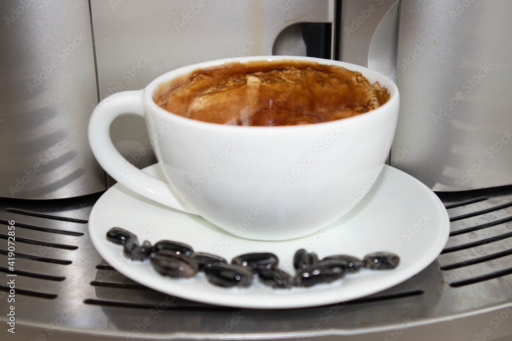 Brewing fresh coffee from your espresso machine. Budget coffee maker. White cup decorated with coffee beans Brewing fresh coffee from your espresso machine. Budget coffee maker. White cup decorated with coffee beans