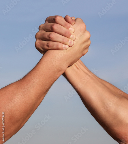 Hand rivalry vs challenge strength comparison. Man hand. Two men arm wrestling. Arms wrestling. Closep up. Friendly handshake, friends greeting, teamwork, friendship. Handshake, arms, friendship photo