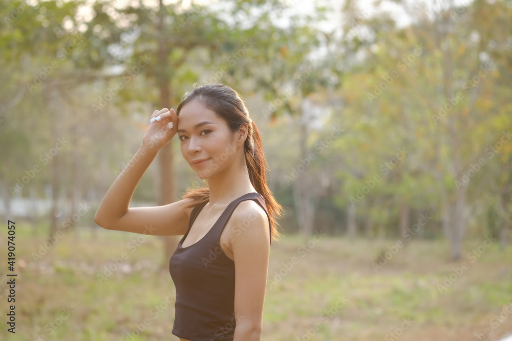 Young woman in sportswear taking a rest after jogging at the park and looking at camera. Young woman in sportswear taking a rest after jogging at the park and looking at camera.