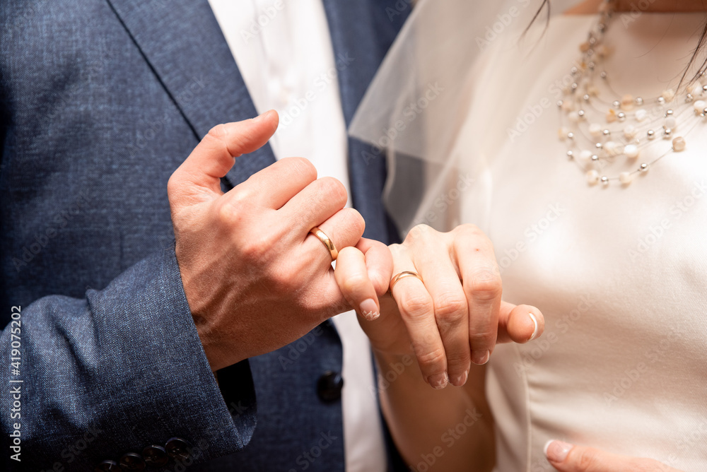 Fototapeta premium The bride puts the ring on to the groom. Wedding
