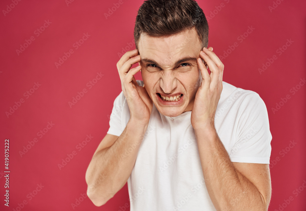 Man with displeased facial expression emotions white t-shirt studio red background Man with displeased facial expression emotions white t-shirt studio red background