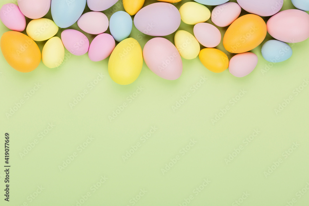 Stylish background with colorful easter eggs pastel colors isolated on green background. Flat lay, top view, mockup, overhead, template