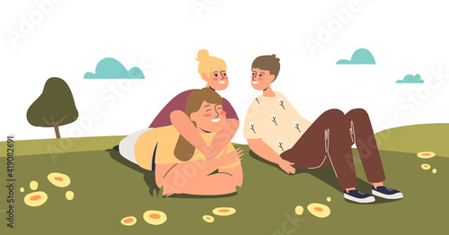 Mom with kids outdoors lying on green grass together. Happy mother with son and daughter