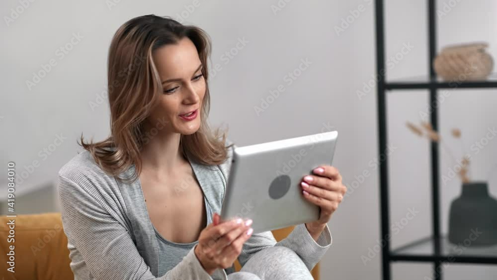 Happy female greeting waving hair communicating online video call tablet. Medium shot on RED camera Happy female greeting waving hair communicating online video call tablet. Medium shot on RED camera