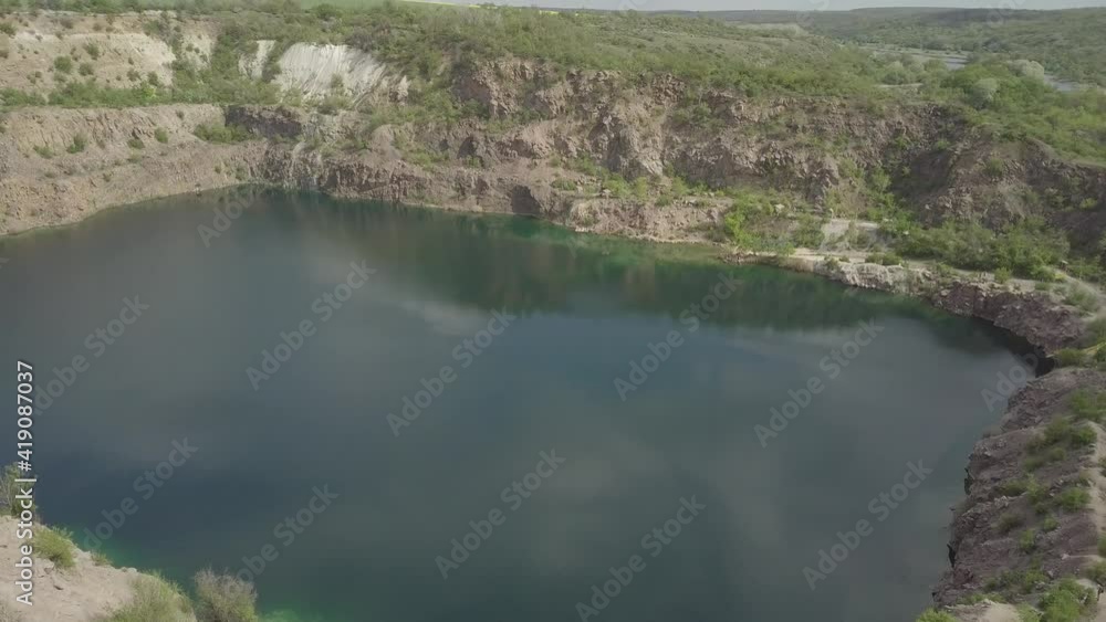 Aerial view to Radon Lake in place of flooded granite quarry near Southern Bug river, Mihiia village, Ukraine. Famous place for rest Aerial view to Radon Lake in place of flooded granite quarry near Southern Bug river, Mihiia village, Ukraine. Famous place for rest