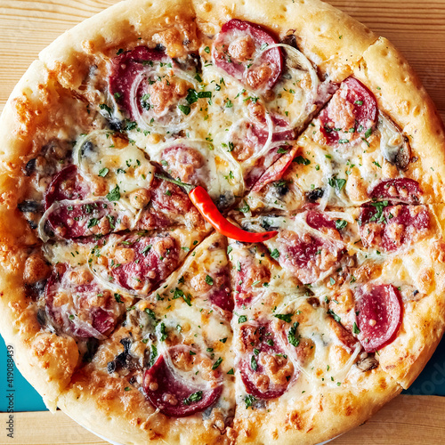 pizza in a plate on a wooden brown table top view