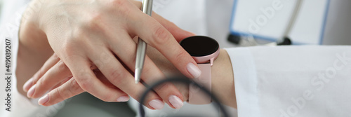 Doctor looking at wrist watch in office closeup