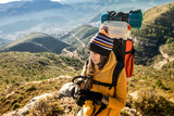 Young girl mountaineer looks at the mountaineering landscape with her backpack on her back