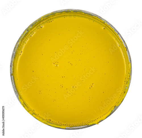 Metal can with yellow paint isolated on white background close-up.