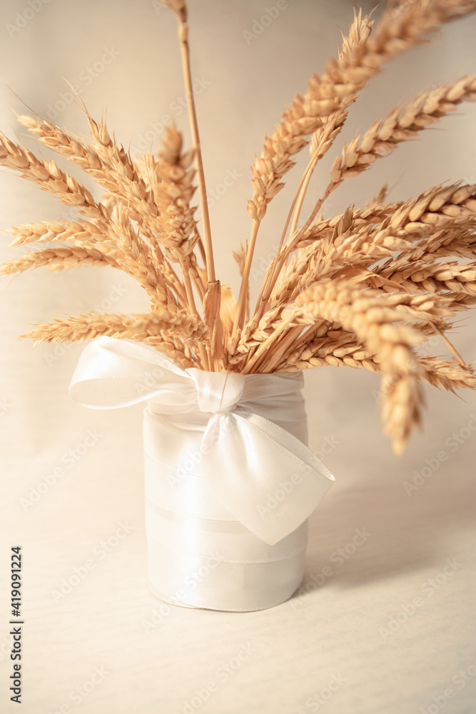 yellow spikelets in a white vase