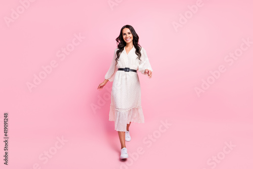 Full body photo of charming happy young lady walk weekend spring isolated on pastel pink color background