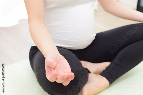 A young pregnant woman is doing fitness at home. .It is important to exercise during pregnancy.