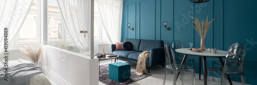 Living room with teal blue wall, panorama