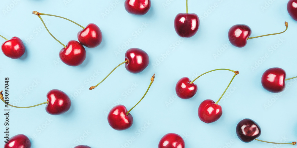 Bright pattern of ripe cherries on a blue background. Flat lay, top view. Bright pattern of ripe cherries on a blue background. Flat lay, top view.