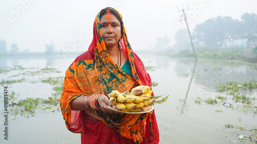 Woman holding fruits in hand during chhath puja photo