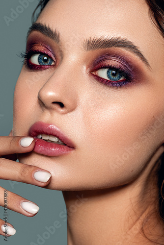 Close-up portrait of a beautiful woman with evening makeup. Strong skin texture. Natural skin, clean healthy skin.