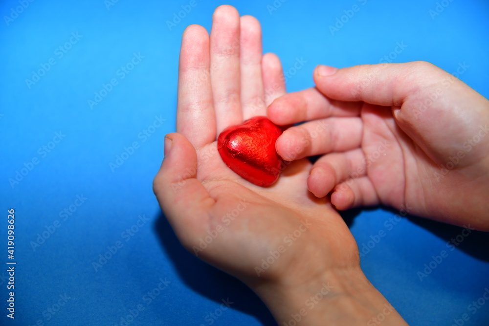 red heart on the palm on a blue background red heart on the palm on a blue background