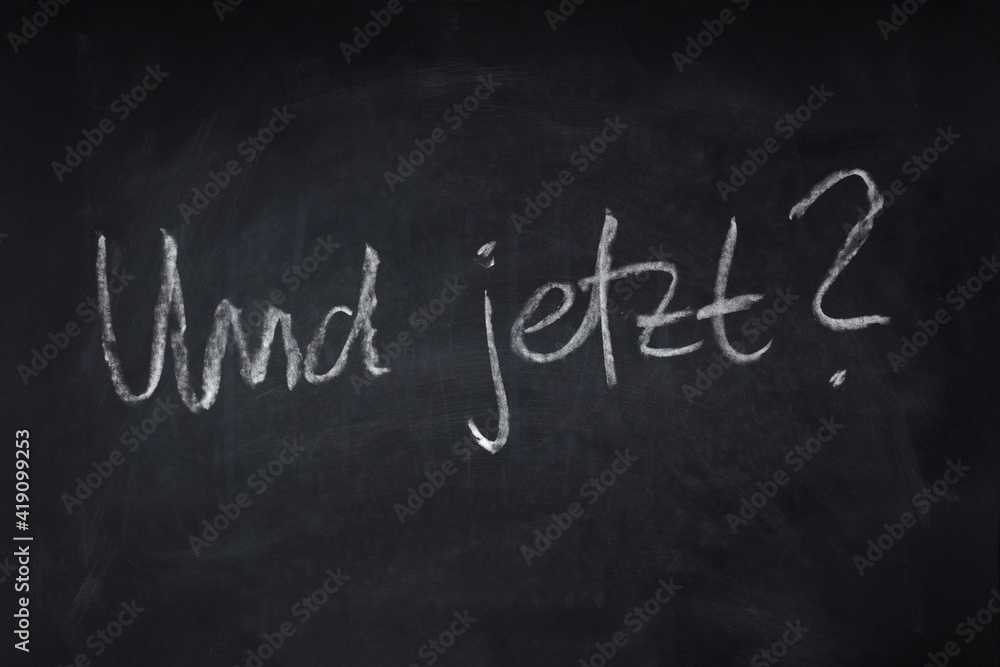 Fototapeta premium Und jetzt ? in Handschrift auf Kreidetafel geschrieben