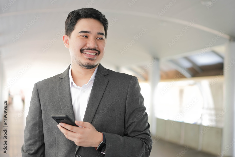 close up adult middle eastern businessman hold smartphone and standing outside office in relax time for lifestyle business concept close up adult middle eastern businessman hold smartphone and standing outside office in relax time for lifestyle business concept