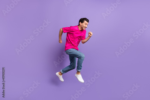 Full size profile side photo of young happy cheerful funky crazy man running in air isolated on purple color background