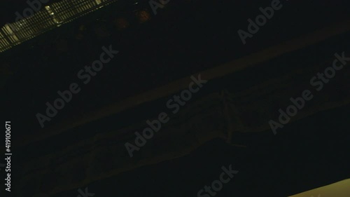 Low angle view up at theater rigging and catwalk as seen from the stage with a pan towards theater lights front of house.