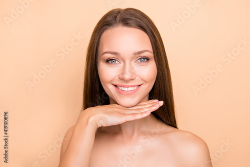 Photo of young girl happy positive smile hand under chin enjoy lifting procedure isolated over beige color background