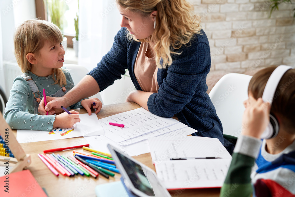 Mother helping children during making homework Mother helping children during making homework