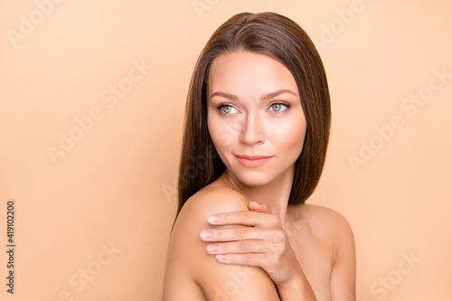 Profile portrait of charming lady hand hug shoulder look empty space no clothing isolated on beige color background