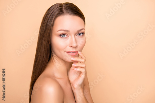 Profile portrait of cute person arm finger touch lip look camera wear nothing isolated on beige color background