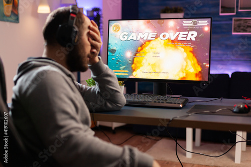 Professional gamer man playing space shooter video game on computer for championship. Cyber performing on powerful pc in gaming room home during online tournament