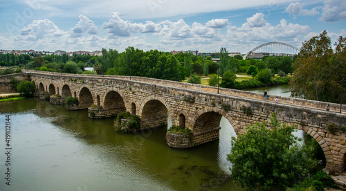 En primer término, el Puente Romano, más lejos la vegetación del río Guadiana y al fondo el Puente Lusitania de la ciudad de Mérida, España